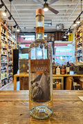 Bottle of Grappa Bianca on a wooden surface with a store interior in the background