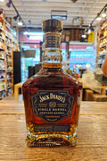 Jack Daniel's Single Barrel Whiskey bottle on a wooden surface with a store interior in the background