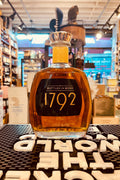 1792 Bottled In Bond 750mL short squat clear glass bottle with gold lettering and a gold top