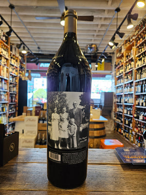 Caymus Cabernet Napa 2021 3L the backside a large robust high shouldered dark glass wine bottle with a label that shows an image of a family and black top
