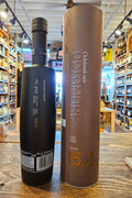 Octomore 15.2 700mL a dark black frosted glass bottle with a slender neck next to a tall brown colored cylinder.