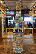 Meletti Dry Anisetta 750mL a clear glass bottle with a white and blue label and a white top