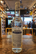 Meletti Dry Anisetta 750mL a clear glass bottle with a white and blue label and a white top