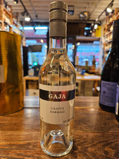 Gaja Grappa Darmagi 375mL a clear glass bottle with a white label and a silver top 