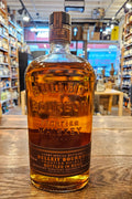 Bulleit Bottled in Bond Kentucky Straight Bourbon 750mL round shouldered clear glass bottle with a brown label and black topper