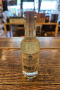 Casamigos Blanco 50mL a small clear glass bottle with a white label and silver top