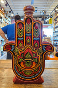 Casa De Hamsa Reposado Tequila 1L a ceramic hand shaped bottle with multi coloring and a wooden top