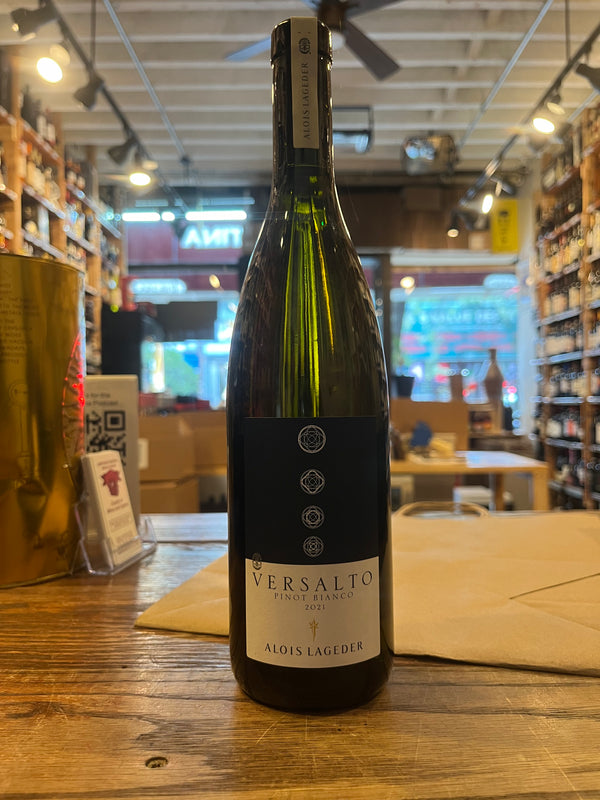 Green wine bottle with wide shoulders, the label is navy blue geometric shapes circles on top and white on bottom with labels saying versalto pinot bianco alois lageder
