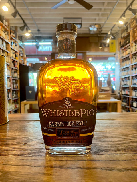 Whistlepig Farmstock Rye Wide Bottle with tall shoulders dark green label and bronze strip on bottom