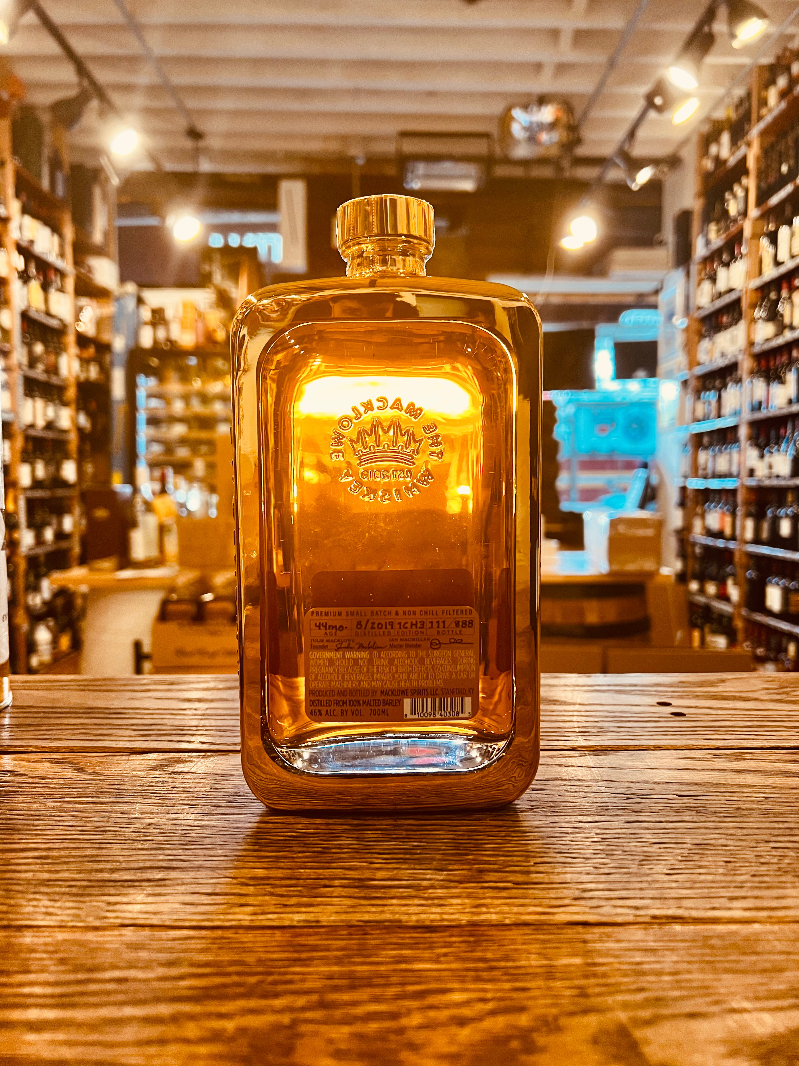 The Macklowe Gold Kentucky Edition 700ml the backside of a squared clear glass bottle with a short stubby neck with a golden cast around the glass bottle and a golden label