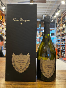 Dom Pérignon 2013 Gift Box 750mL a tall black box with gray labeling next to a green clear champagne bottle with a gray label and black top