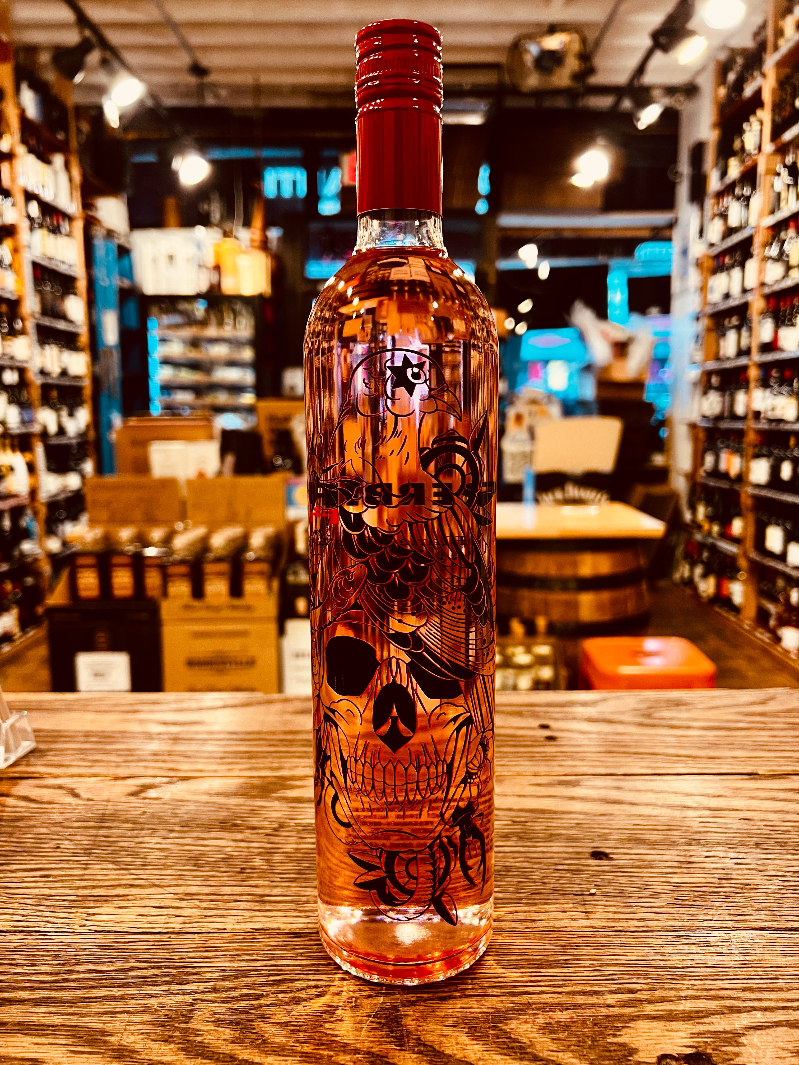 Superbird Fuego 750ml Tequila a tall slender clear glass bottle with a red top and the image of a skull and eagle on the bottle