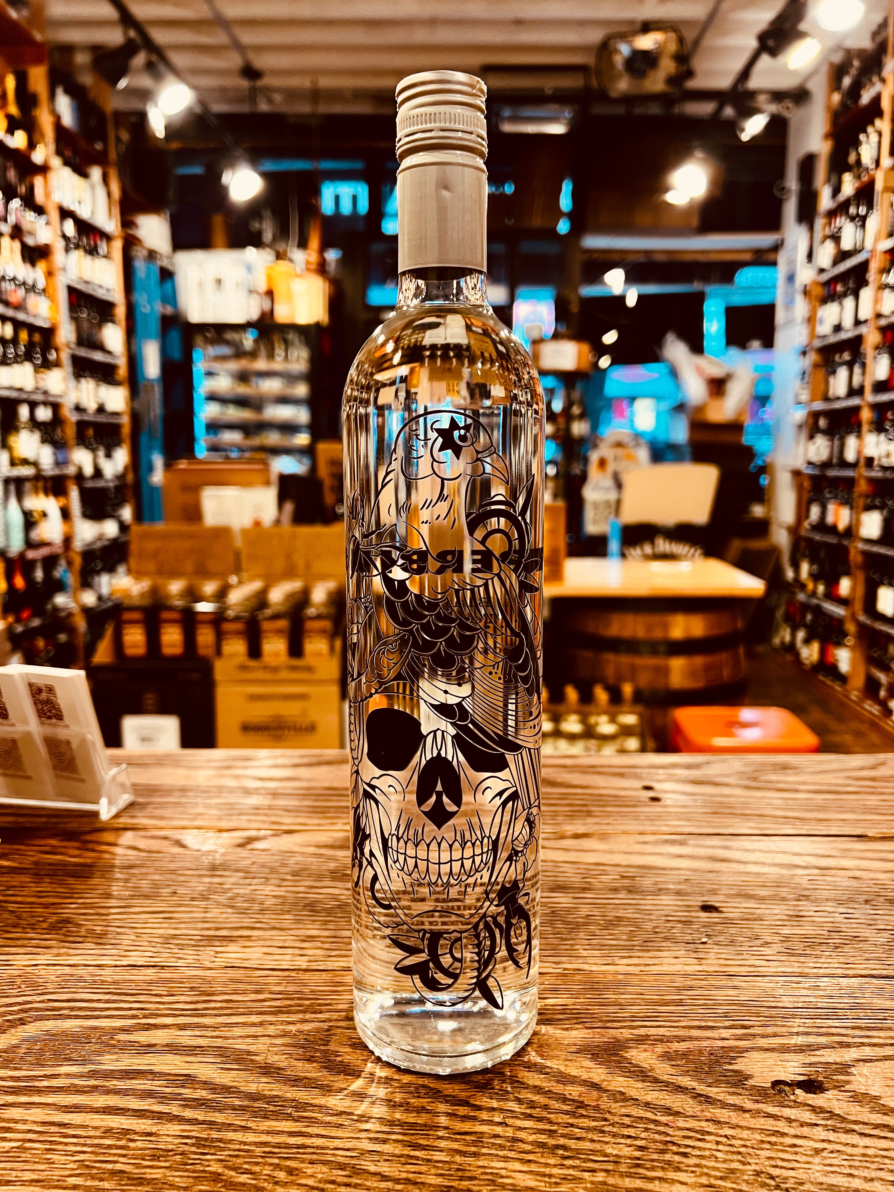 Superbird Blanco 750ml Tequila a tall slim clear glass bottle with a silver top and the image of a skull and eagle on the bottle