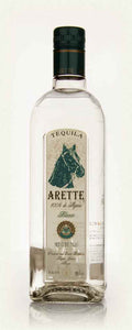 Arette Blanco 1L a tall squared clear glass bottle with a beige label with the image of a horse head on it with a green top