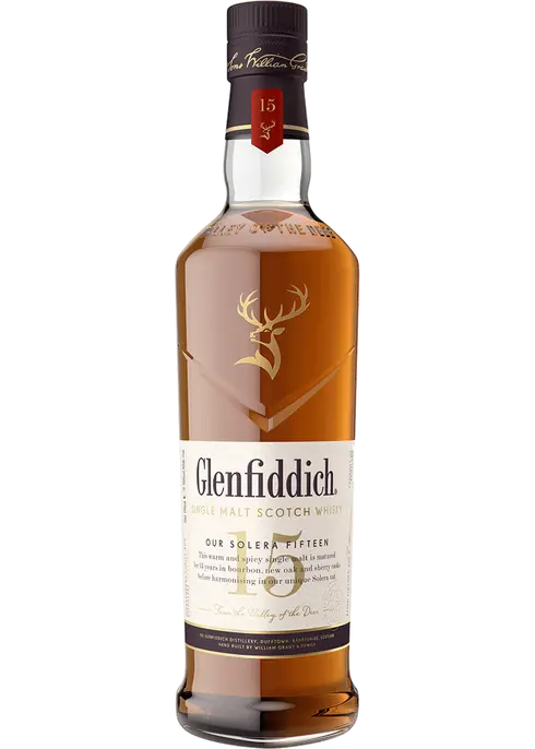 Glenfiddich Sing Malt Scotch 15 year tall angulated clear bottle with a white label and a golden deer emblem  