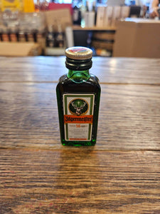 Jagermeister 20mL a small flat faced squared green glass bottle with white label