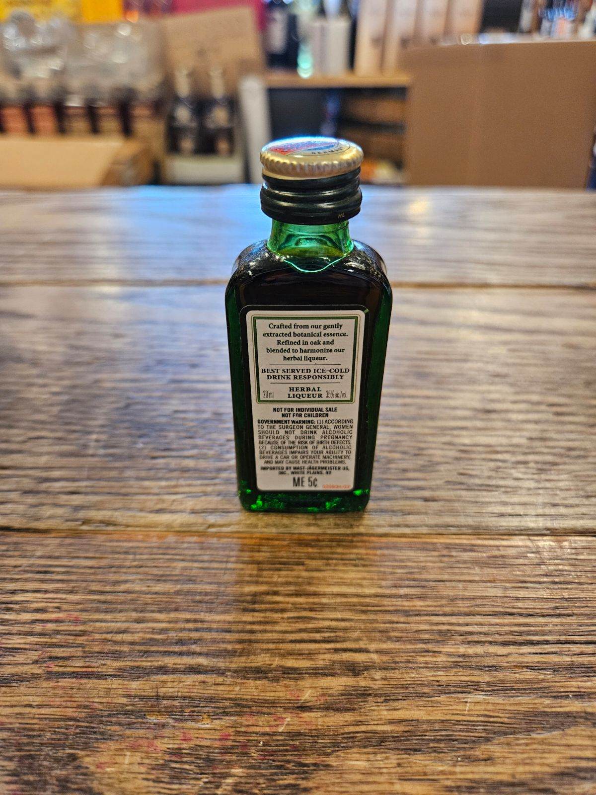 Jagermeister 20mL the backside a small flat faced squared green glass bottle with white label