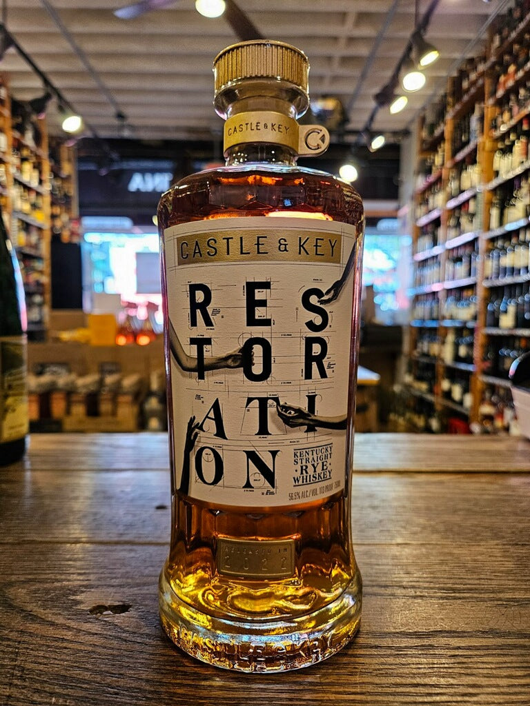 Castle & Key Restoration Rye Whiskey 750mL a wide shouldered roundish clear bottle with a white label and a gold top