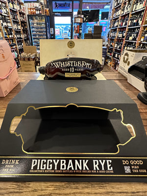 Whistle Pig Piggybank Rye 1L a clear glass bottle shaped like a pig behind a black back with the outline of a pig on it