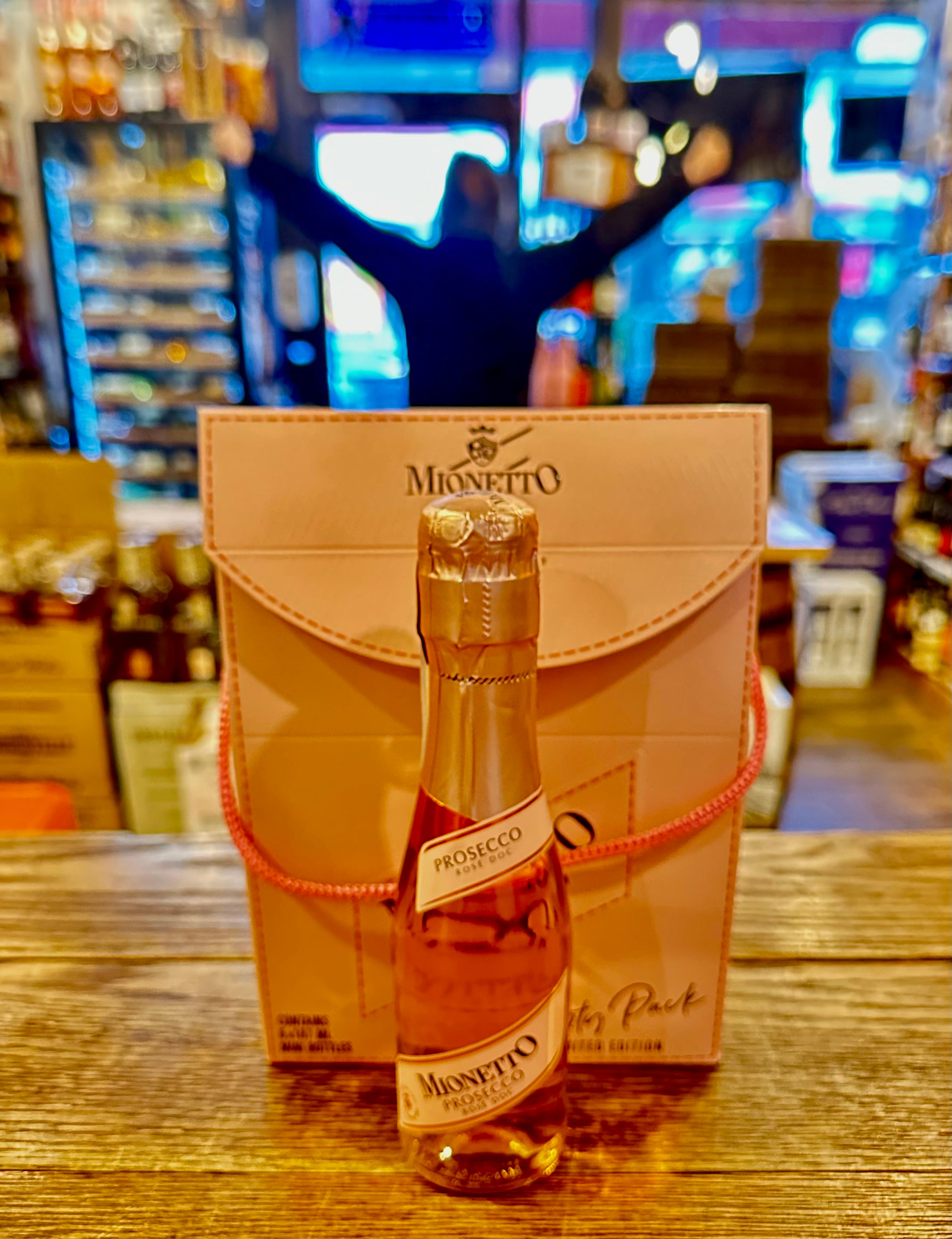 Mionetto Prosecco Rose 187mL a small clear glass champagne bottle with a pink label and a pink top, displayed in front a of small pink box 