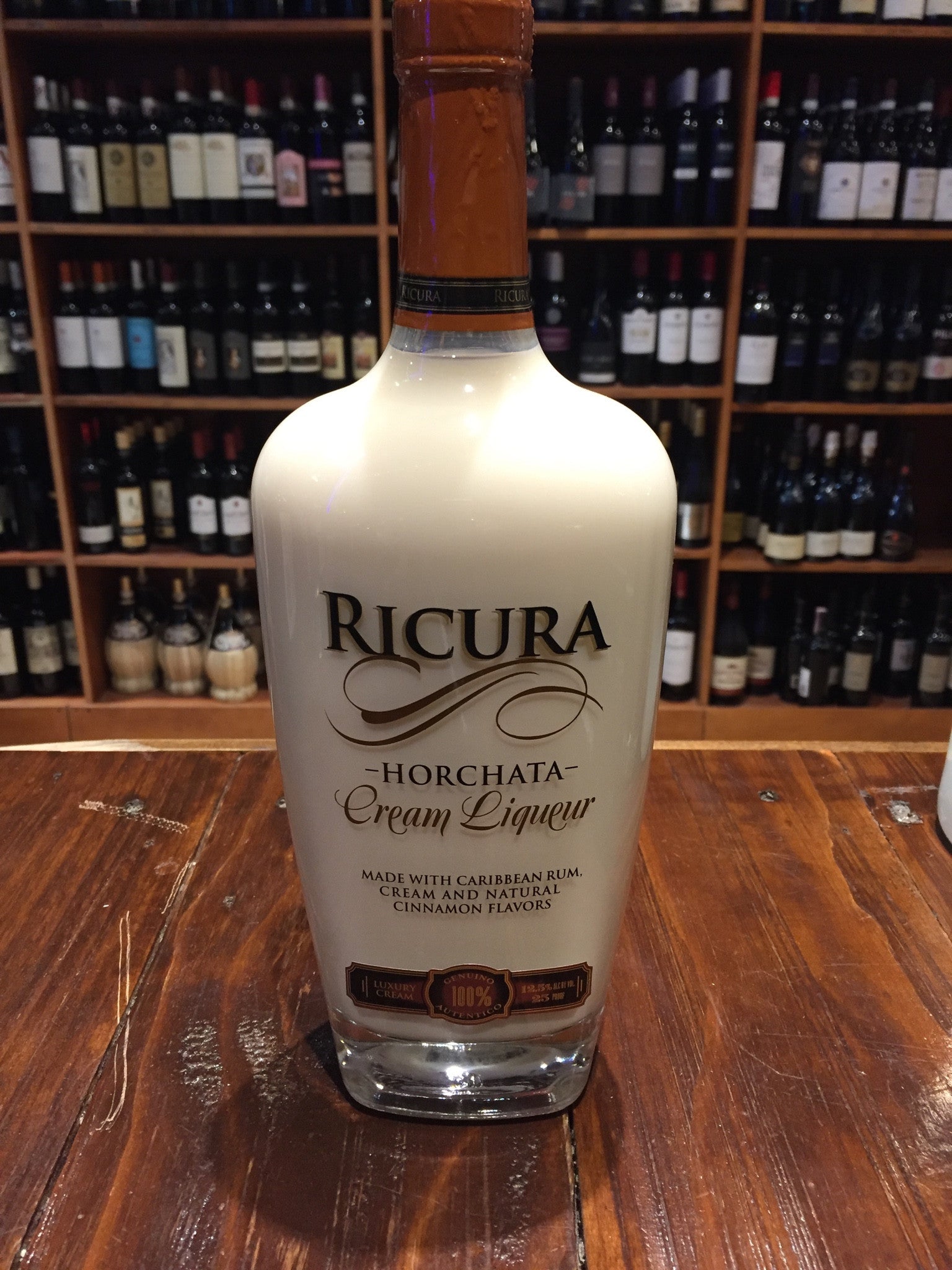 Ricura Horchata Cream Liquer 750ml a rounded high shouldered clear glass bottle with brown and black lettering and a brown top