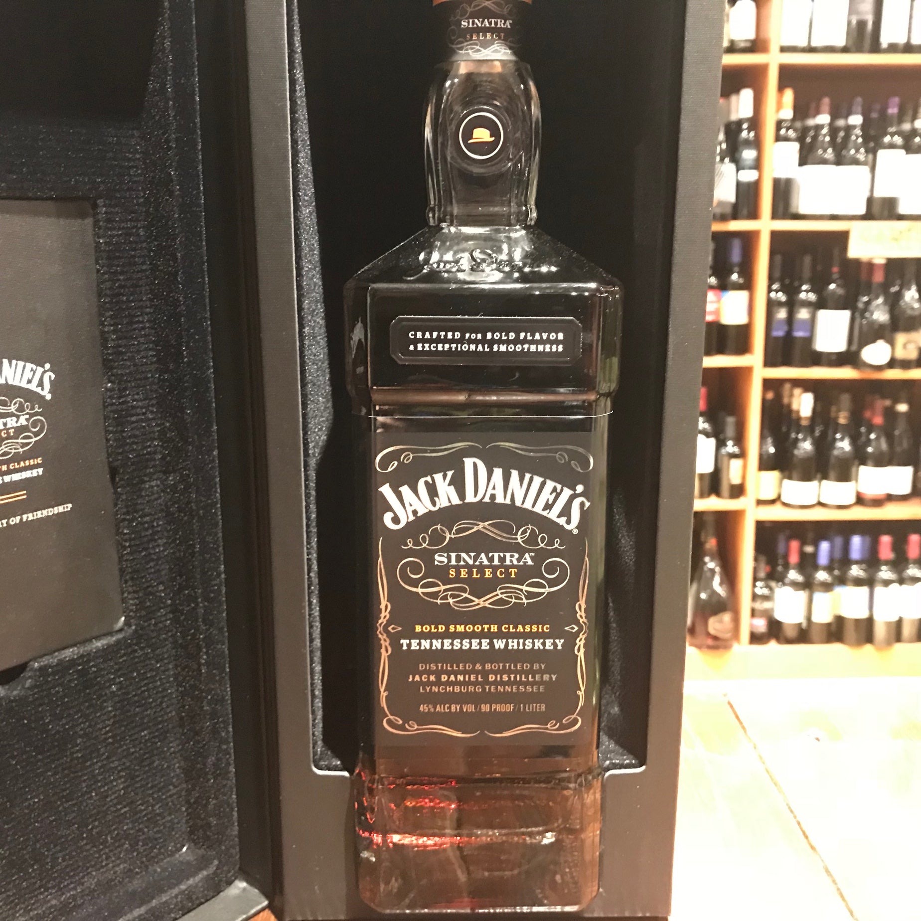 Jack Daniels Sinatra Select 1L a large  tall squared tall clear glass bottle with a black label inside of a black velvet lined box