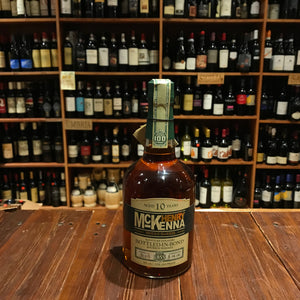 Henry McKenna Bottled in Bond 750mL a bottom heavy round shouldered clear glass bottle with a beige and green label and green top