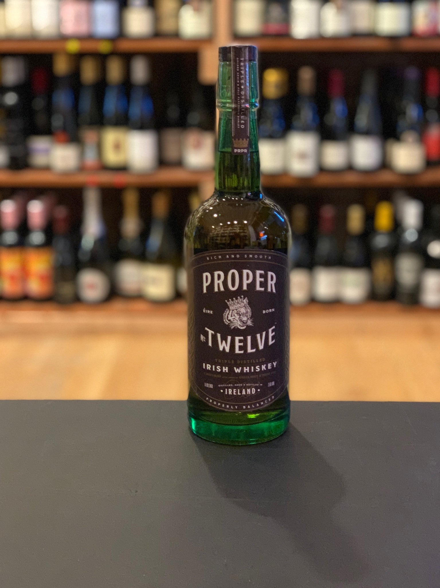 Proper Twelve 12 750mL a green glass bottle with a black label and black top