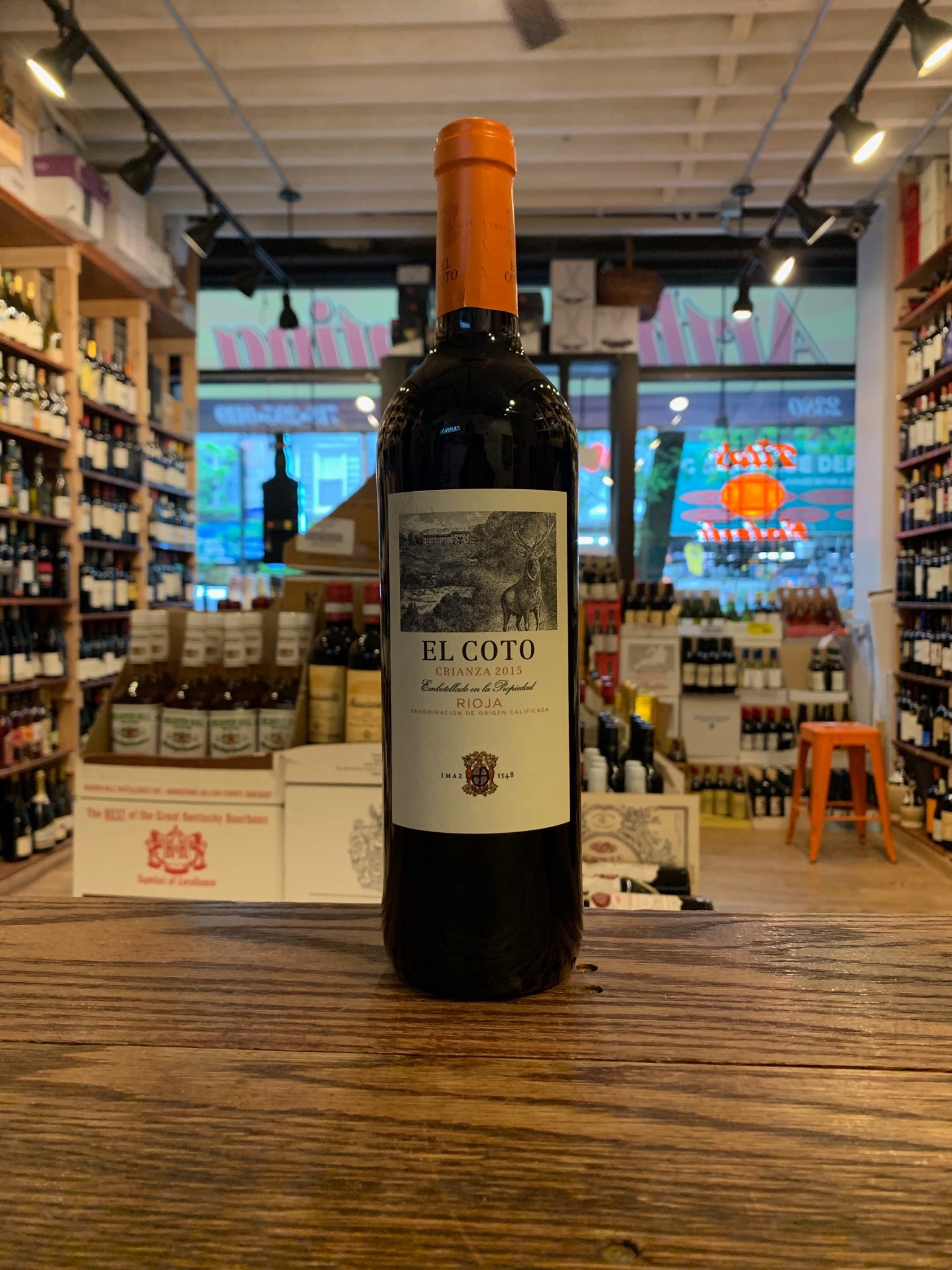 El Coto Crianza Rioja 750ml a dark wine bottle with a white label and orange top