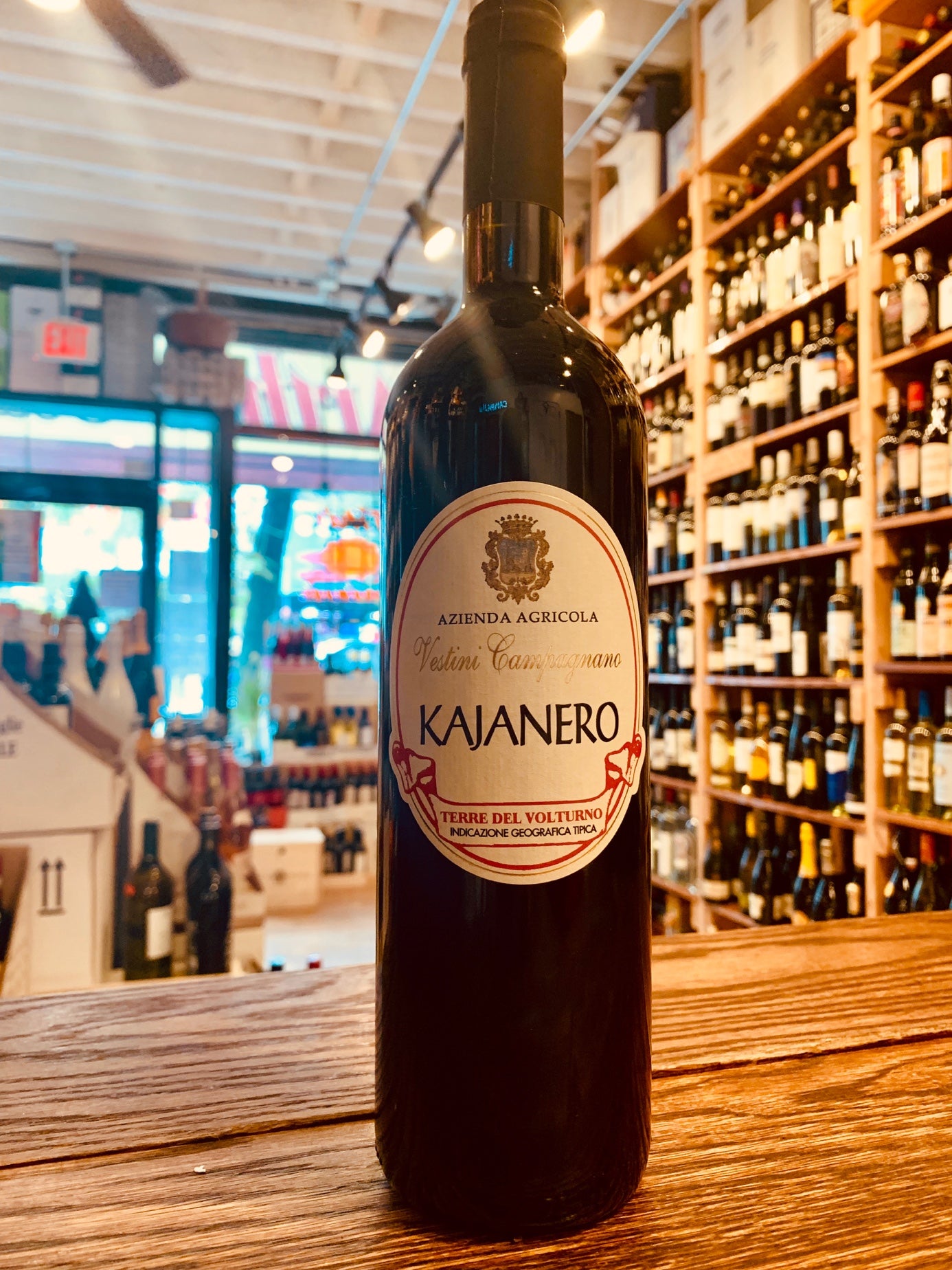 Vestini Campagnano Kajanero 2017 750mL a tall dark glass wine bottle with a white circular label and a black top