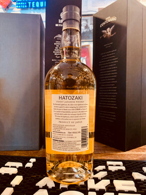 Hatozaki Finest Japanese Whisky 750mL the backside of a clear tall rounded shouldered bottle with a white label and light gray top