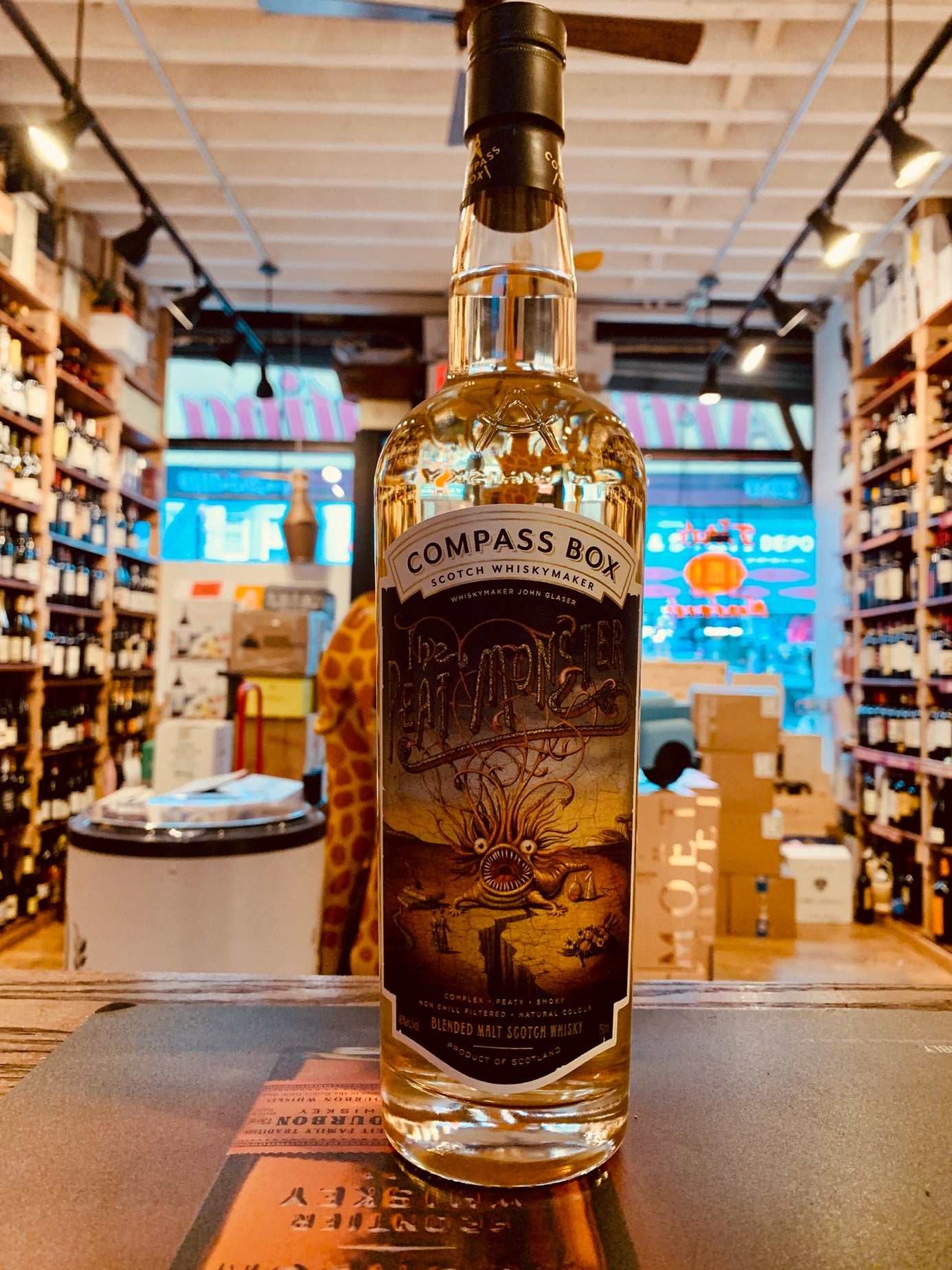 Compass Box The Peat Monster 750mL clear tall bottle with a colorful label design and a black top