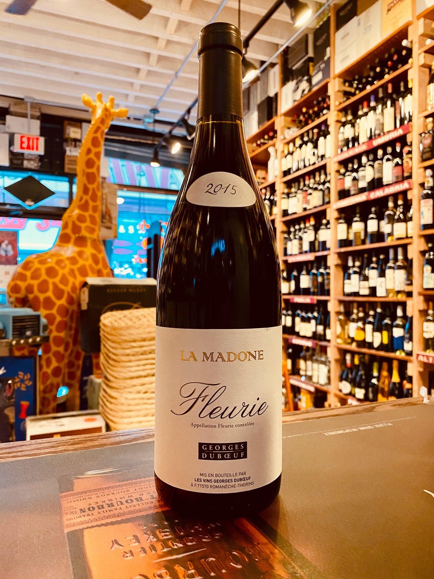 La Madone Fleurie 2015. 750mL a dark wine bottle with a white label and black top