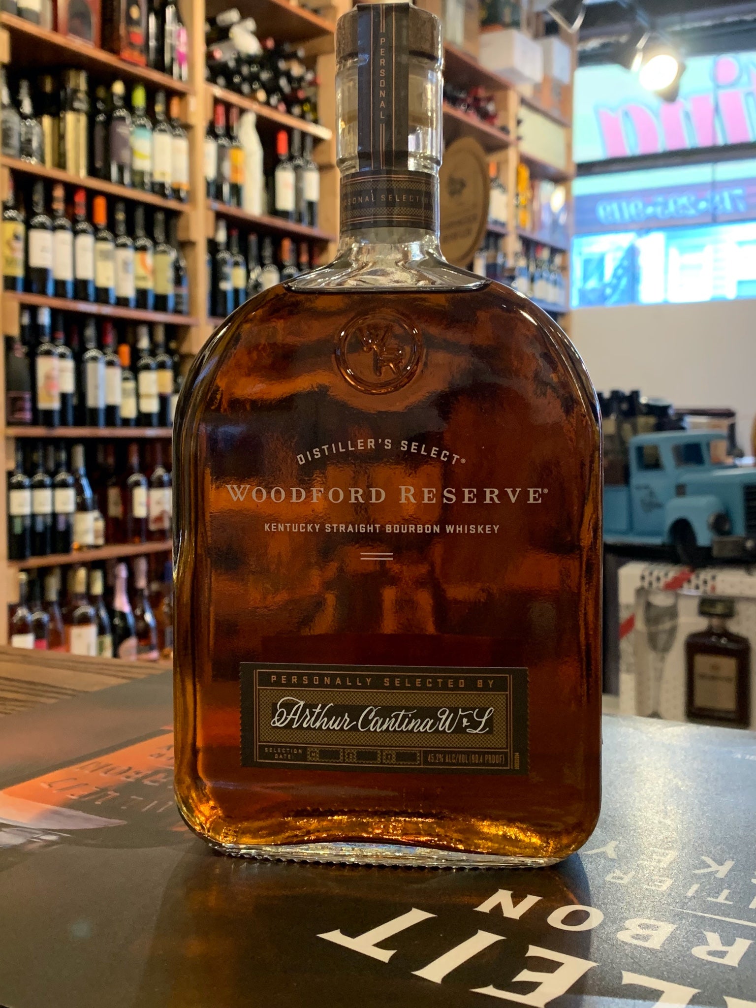 Woodford Reserve Bourbon Personal Selection 1L a flat surfaced round shouldered clear glass bottle with a brown label on the bottom and white lettering on the front and a wooden top