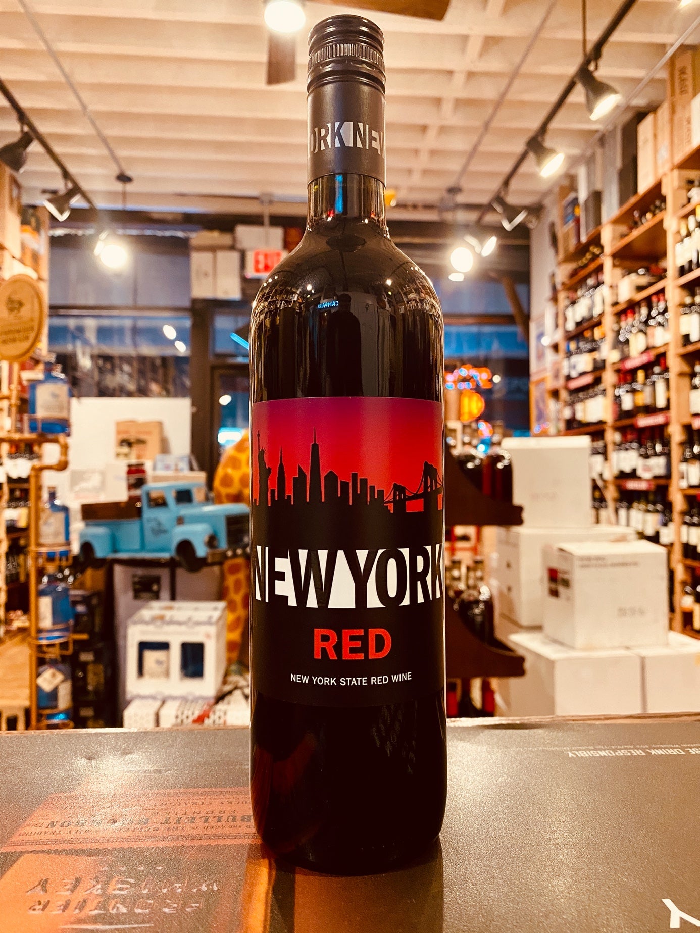 New York Red 750 mL a dark glass wine bottle with a red and black label with the image of the New York skyline on it.