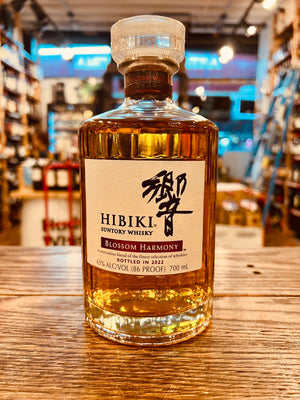 Hibiki Whiskey Blossom Harmony 750mL a small circular squat clear glass bottle with a white label 