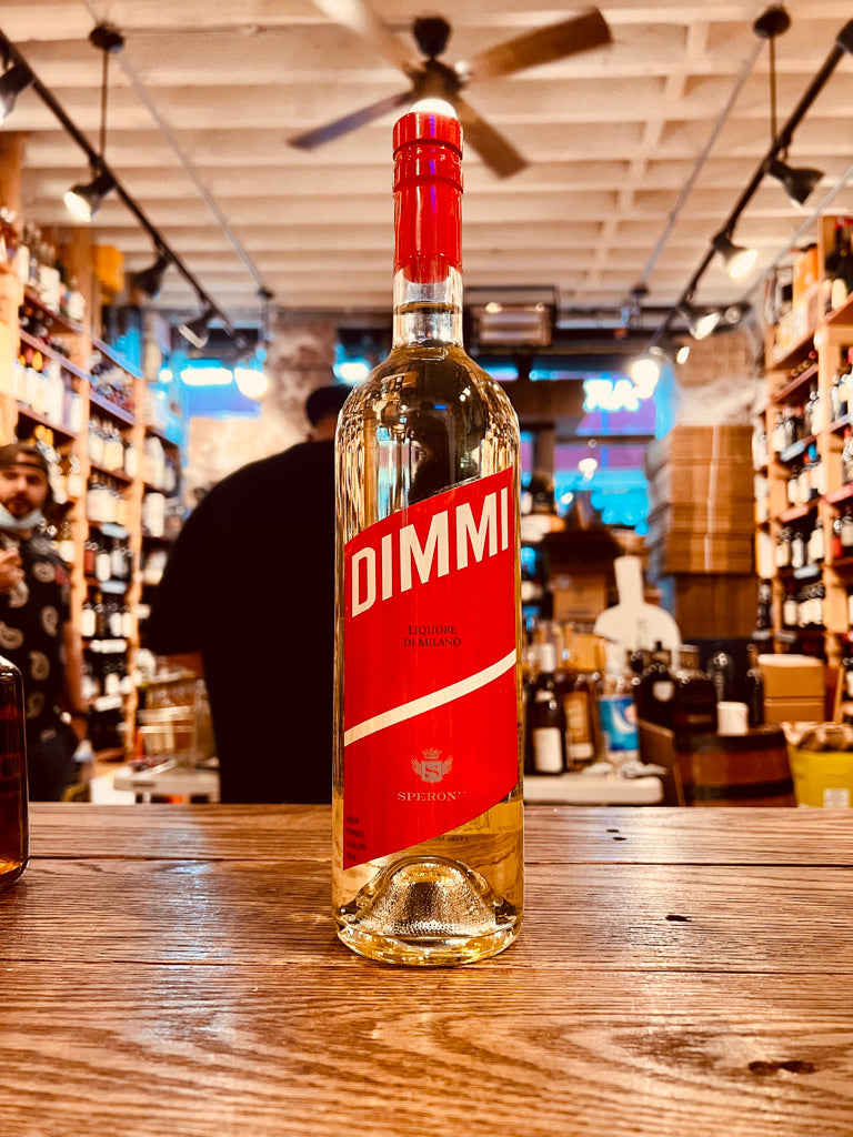 Dimmi Liquore di Milano 750mL a tall slender clear bottle with a red label and red top