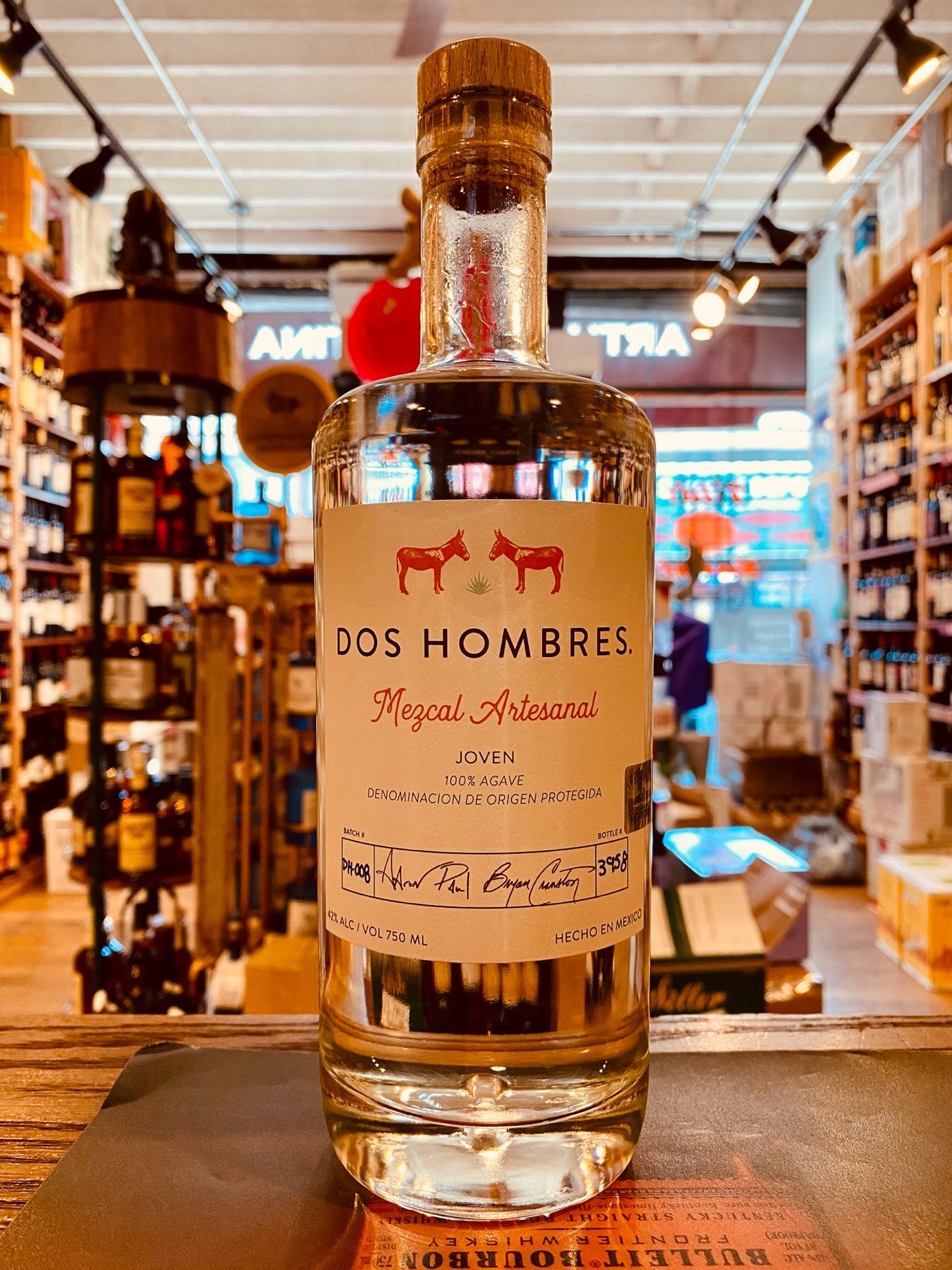 Dos Hombres Mezcal Joven 750mL clear round shouldered bottle with a white label and wooden top