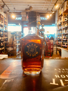Blade & Bow Bourbon 750mL small squared squat bottle with a dark blue and gold label and a key amulet hanging off the neck