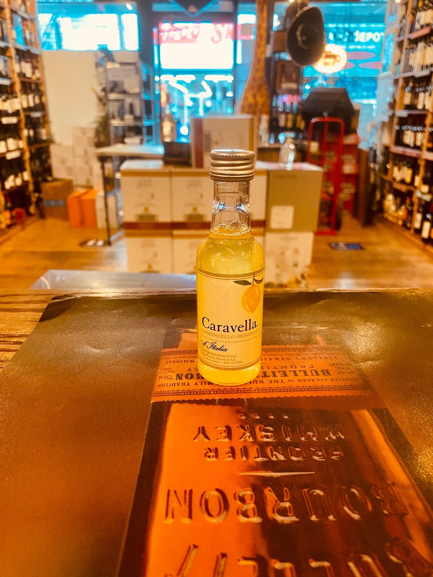 Caravella Limoncello 50mL small clear bottle with a yellow liquid and a yellow label with a silver top