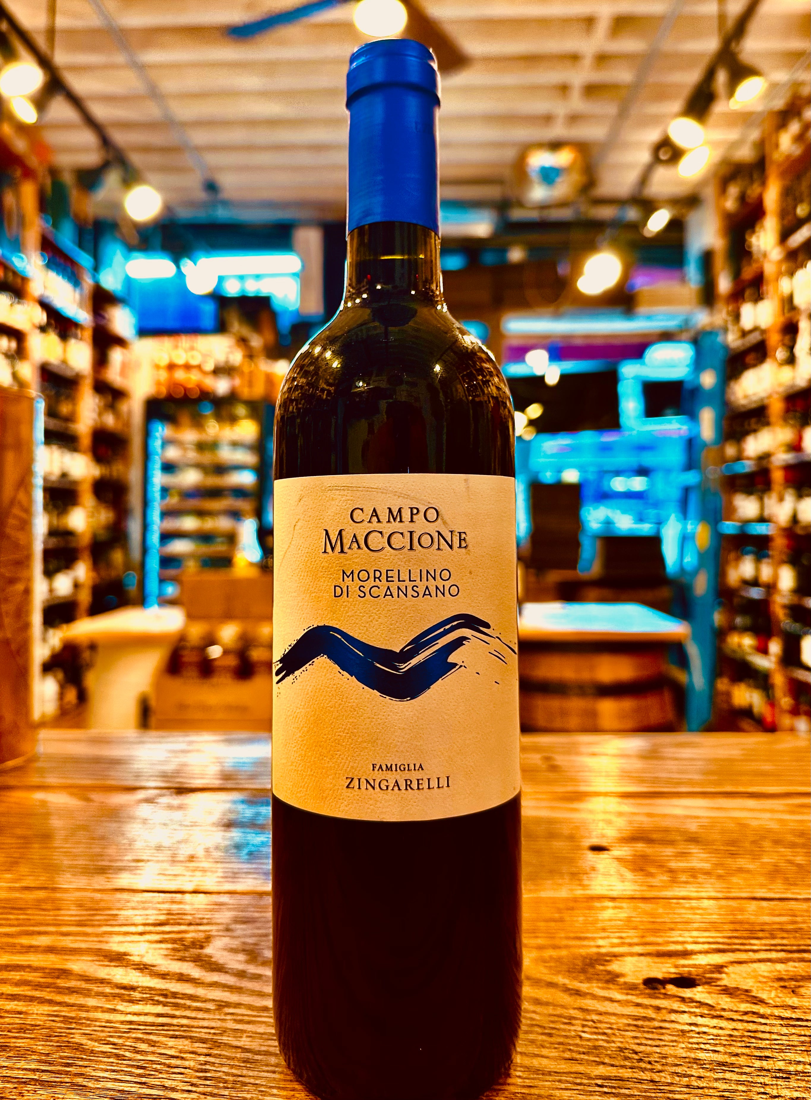 Campo Maccione Morellino di Scansano 750ml a dark wine bottle with a white label and a bright blue top