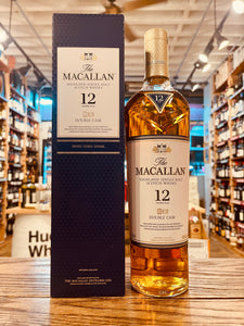 Macallan 12yr Double Cask 750ml a tall blue box with a white label next to a tall slender clear glass bottle with a white label and golden top