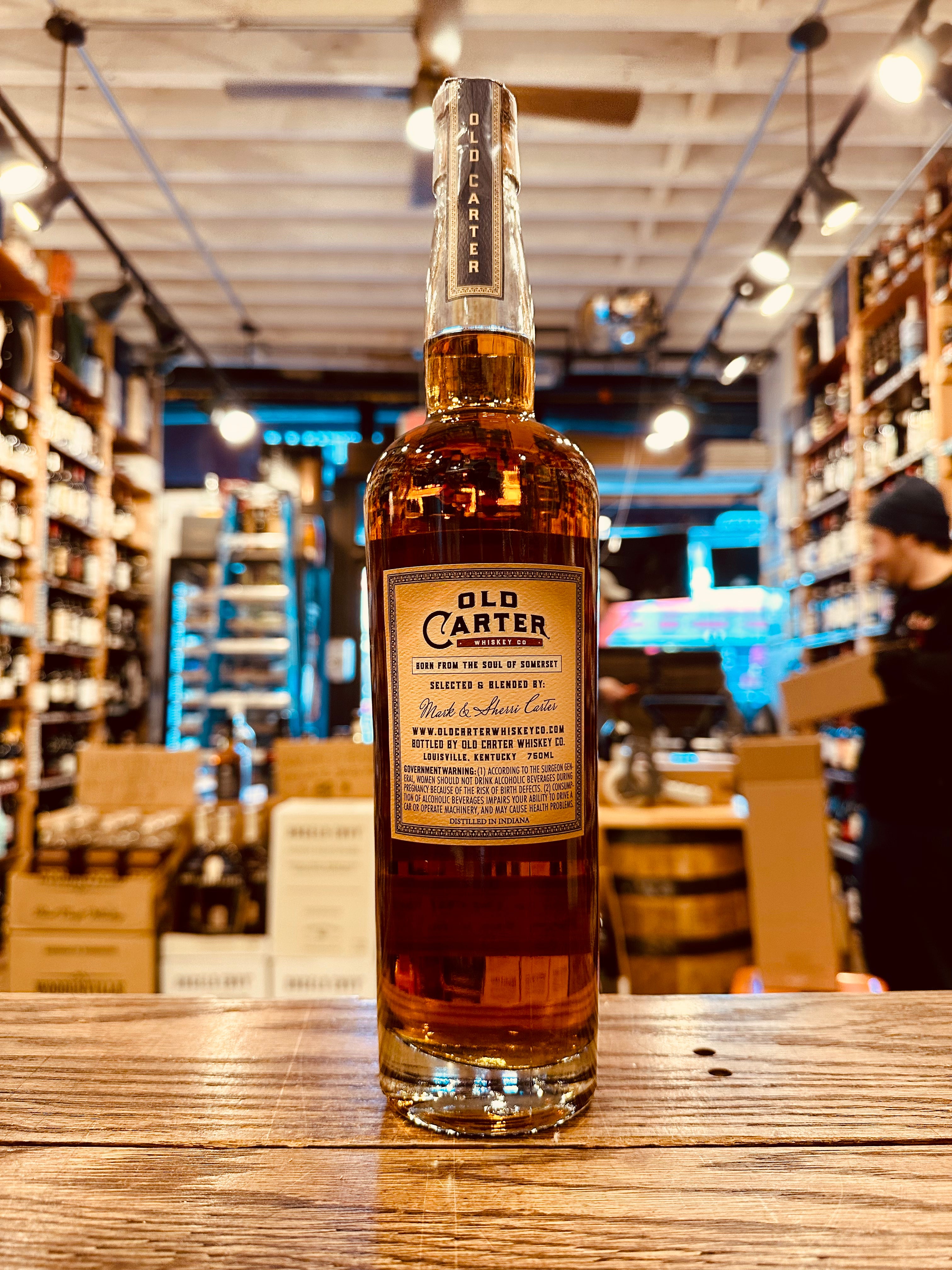 Old Carter Straight American Whiskey Batch 10 750mL the backside a of a tall large clear glass bottle with a beige label and wooden topper