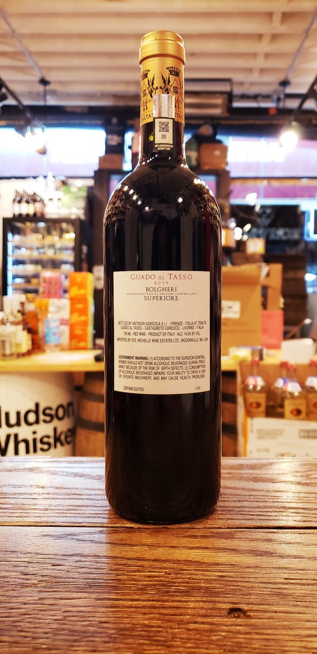 Guado Al Tasso 2019 Bolgheri the backside of a tall dark wine bottle and white label with a golden top