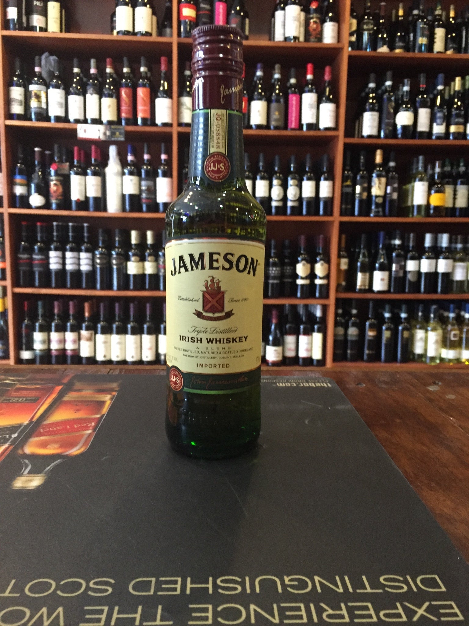 Jameson 1L a green clear glass tall bottle with a beige label and maroon top