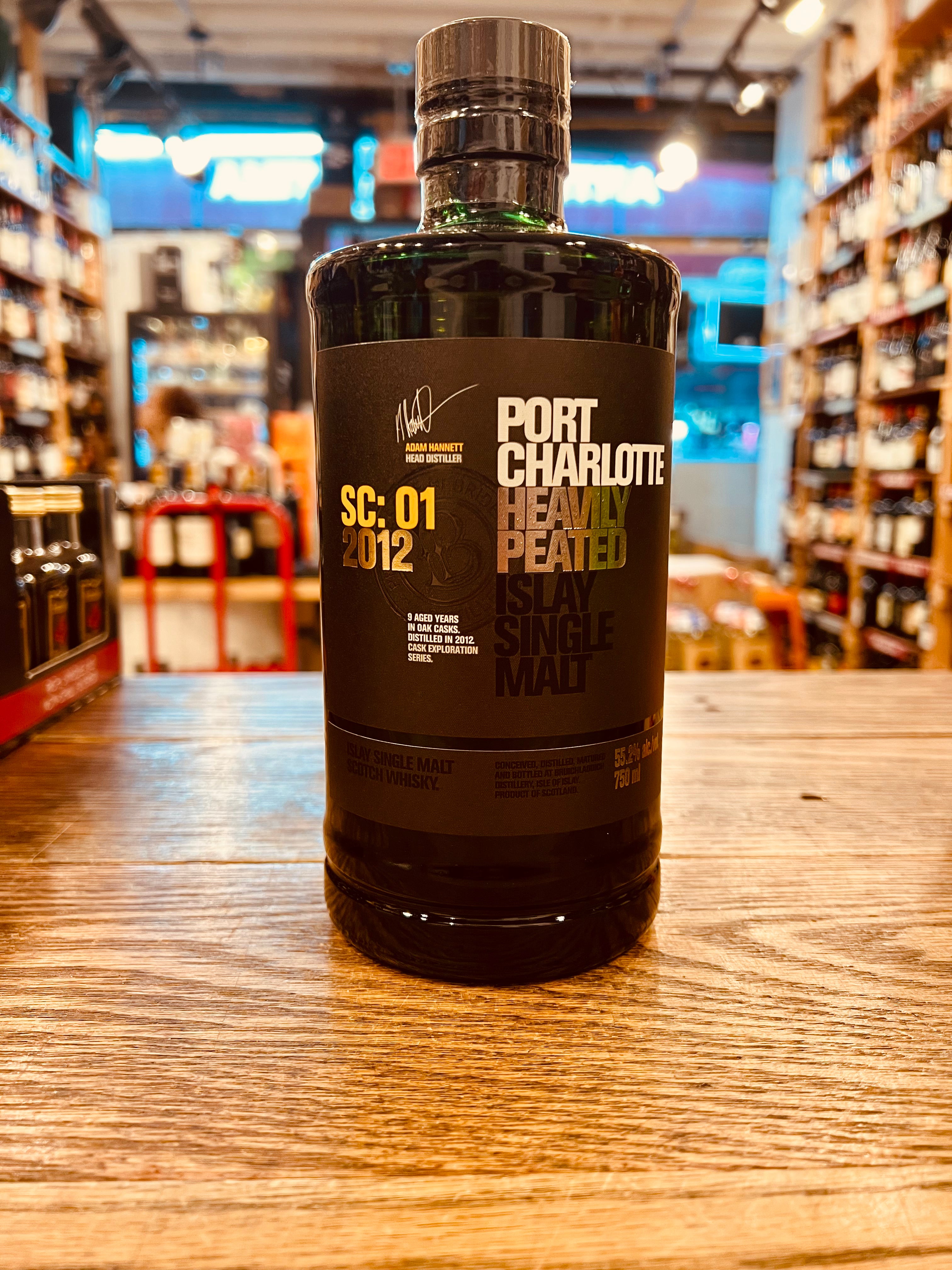 Port Charlotte SC:01 750mL a short stubby necked round shouldered dark green glass bottle with a black label and black top
