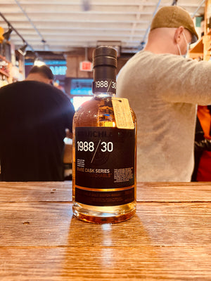 Bruichladdich Rare Cask Series 1988 / 30 Year Aged 750mL a clear bottle with a black label and top with a metal medallion hanging off the neck