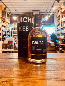 Bruichladdich Rare Cask Series 1988 / 30 Year Aged 750mL a clear bottle with a black label and top in front of a metal black canister 