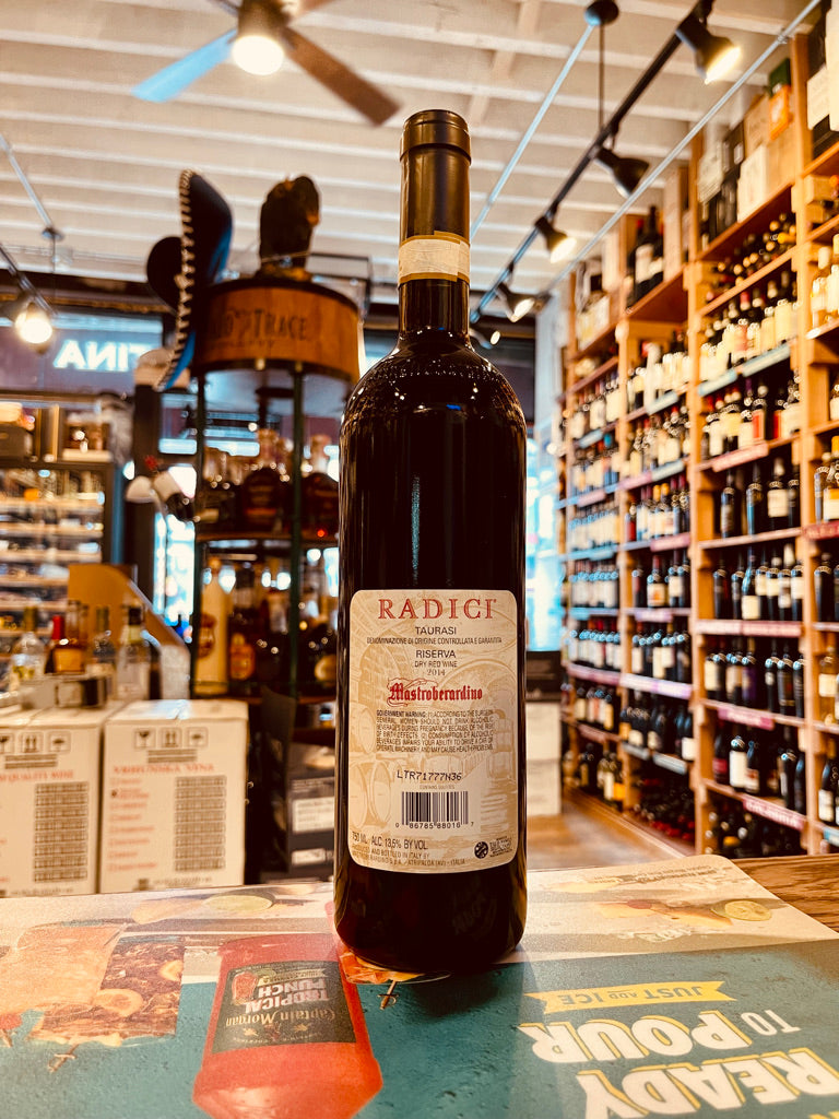 Radici Taurasi Riserva Mastroberardino 2014 750mL the backside of a tall dark glass wine bottle with a white and red label and black top