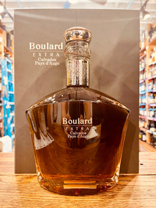 Boulard Extra Calvados Pays d’Auge 750mL a clear square rounded bottle with a silver topper in front of a silver colored box